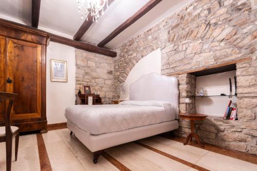 a bedroom with a stone wall with a bed in it at La Cantina del Convento in Potenza