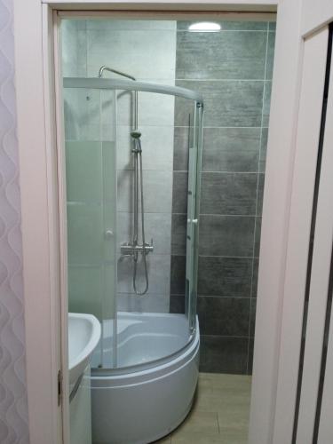 a bathroom with a shower and a tub and a sink at Квартира-студія in Odesa