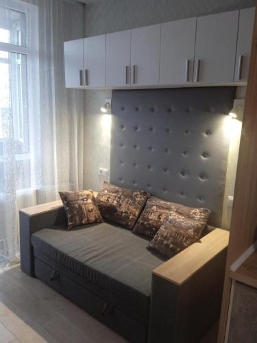 a bed with pillows on it in a room at Квартира-студія in Odesa