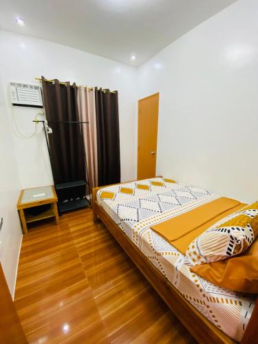 a bedroom with a bed and a wooden floor at Lucas Transient House in Looc