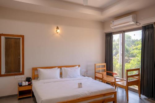 a bedroom with a bed and a large window at Daksh The Nirvana Retreat in Vitoj