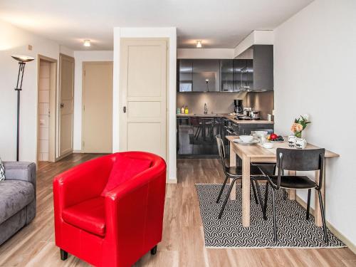 a living room with a red chair and a table at Studio Diure 0113 by Interhome in Verbier
