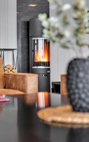 a kitchen with a stove with a fire in it at Robukta Lodge l Jacuzzi l Sauna l Table Tennis in Tromsø