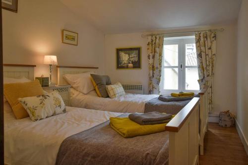 a bedroom with two beds and a window at La Maison Muguet in Civray