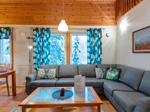 a living room with a couch and a table at Holiday Home Aamutähti by Interhome in Äkäslompolo