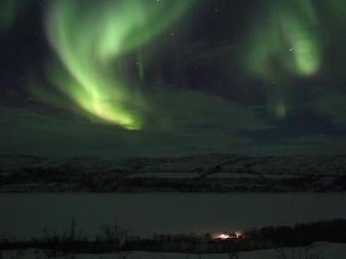 an aurora in the sky over a body of water at Holiday Home Karetörmä by Interhome in Nuorgam