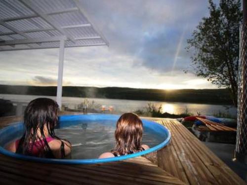 two girls sitting in a hot tub at a resort at Holiday Home Karetörmä by Interhome in Nuorgam