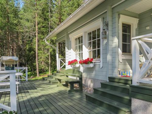 a porch of a house with a bench and flowers at Holiday Home Sipukka by Interhome in Meltaus