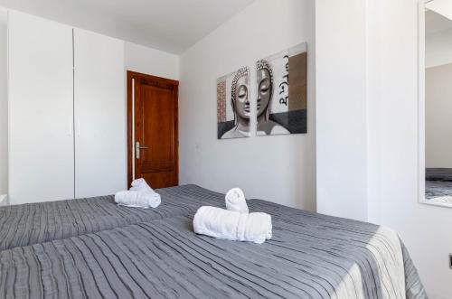 a bedroom with two white towels on a bed at Yourhouse Blau Blue 2 3 in Can Picafort