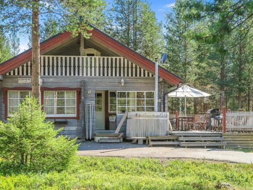 a small cabin with a porch and an umbrella at Holiday Home Kerkkälä by Interhome in Luosto