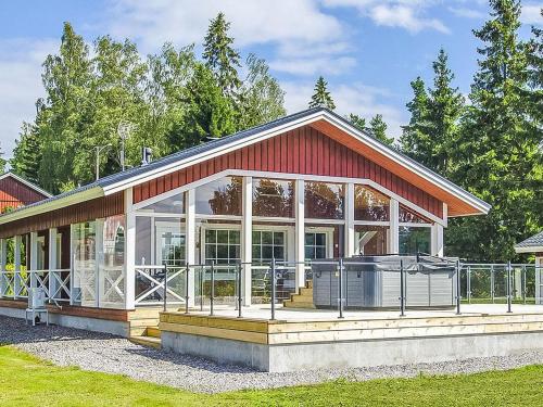a house with a large screened in porch with at Holiday Home Villa blomvik by Interhome in Kristenäs