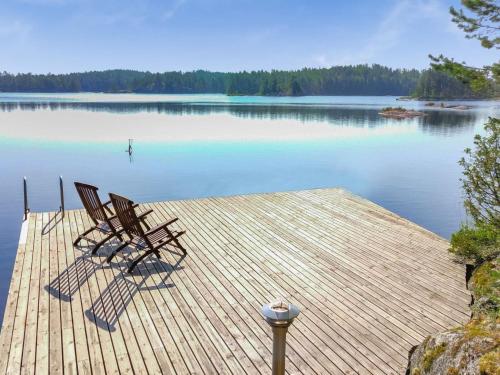 two chairs sitting on a dock on a lake at Holiday Home Sointukallio by Interhome in Savonlinna