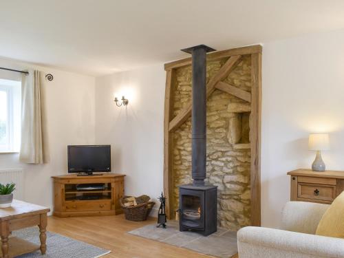 a living room with a fireplace and a tv at Cherry Cottage - Ukc3990 in South Perrott