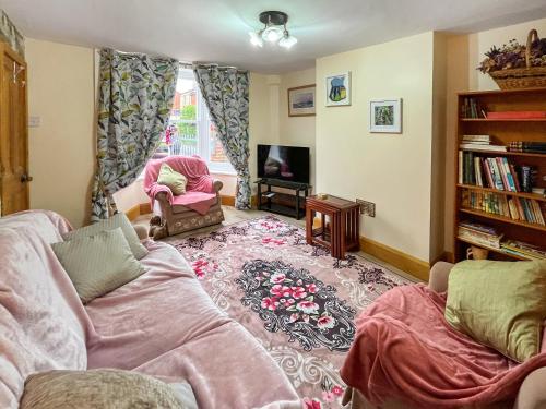 a living room with a couch and a tv at The Painters Cottage in Heckington