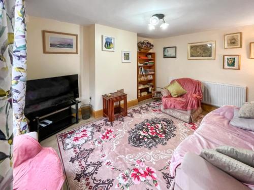 a living room with a couch and a television at The Painters Cottage in Heckington