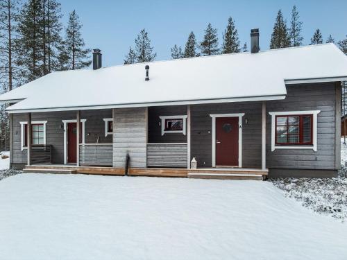 a house covered in snow with a driveway at Holiday Home Maaruska a by Interhome in Äkäslompolo
