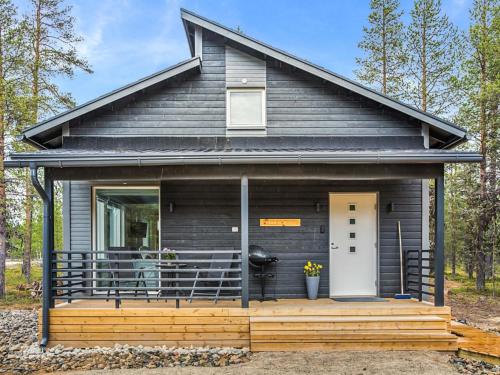 a small black house with a porch and a door at Holiday Home Pallaskieppi by Interhome in Kyrö