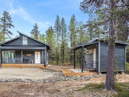 a black tiny house in the woods with a porch at Holiday Home Pallaskieppi by Interhome in Kyrö