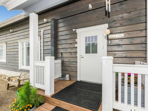 a wooden house with a white door and a porch at Holiday Home Suviranta by Interhome in Suonenjoki