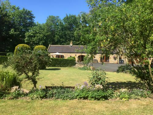 a large stone house with a garden in front of it at Rivers Edge Cottage in Shotley Bridge