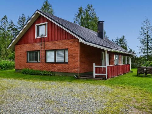 a red brick house with a porch and a bench at Holiday Home Oriaho by Interhome in Iisalmi