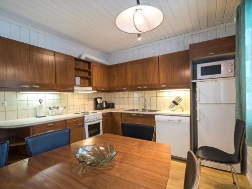 a kitchen with wooden cabinets and a wooden table at Holiday Home Lomamaja 1 by Interhome in Raattama