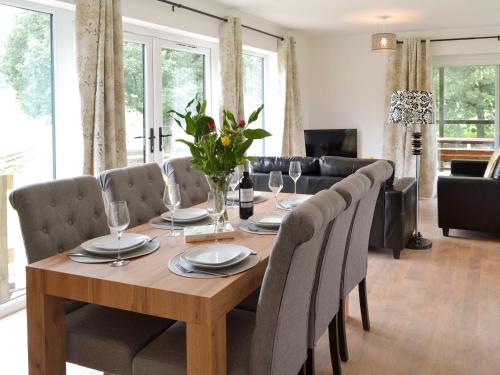 a wooden table with chairs and a dining room at Larch Lodge in Bentley