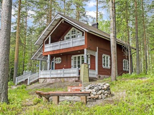a log cabin in the woods with a picnic table in front of it at Holiday Home Honkaniemi by Interhome in Rasivaara