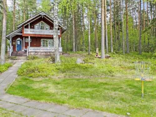 a house in the woods with a basketball hoop at Holiday Home Honkaniemi by Interhome in Rasivaara