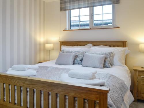a bedroom with a large bed with white pillows at Clover Cottage in Keswick