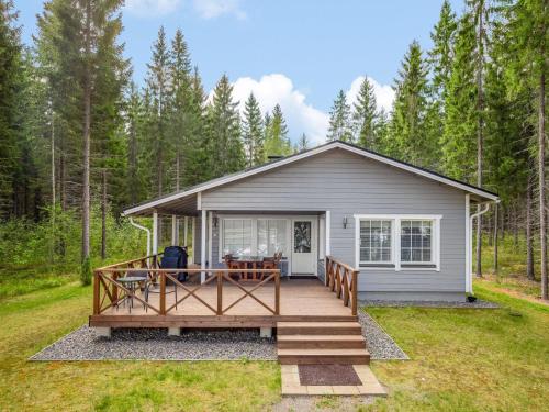 a tiny house with a deck in the woods at Holiday Home Kaisla by Interhome in Pertunmaa