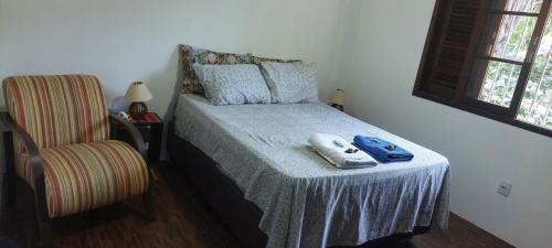 a bedroom with a bed with a pair of shoes on it at Quarto Suíte Amora in Atibaia