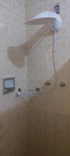 a shower with a shower head in a bathroom at Quarto Suíte Amora in Atibaia