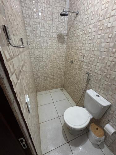 a bathroom with a white toilet in a shower at Cajuí da Vila Atins in Atins
