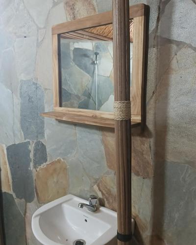 a bathroom with a sink and a mirror at REFUGE du MONT AGOU in Liatonou