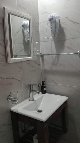 a bathroom with a sink and a mirror and a hair dryer at Bom Descanso in Realicó