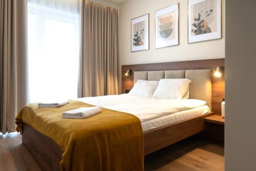 a bedroom with a bed with two towels on it at Willa Zieleniec - apartamenty z Ogrodem SPA in Duszniki Zdrój