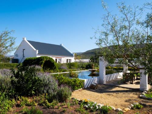 a garden with chairs and a house and a pond at Sempurna Estate in McGregor