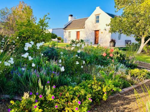 a garden with flowers in front of a house at Sempurna Estate in McGregor