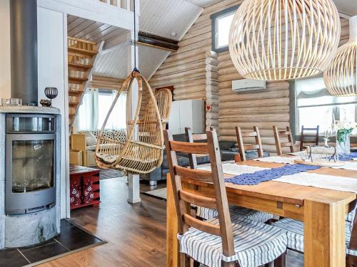a dining room with a table and chairs and a fireplace at Holiday Home Isopyhänmaa by Interhome in Salla
