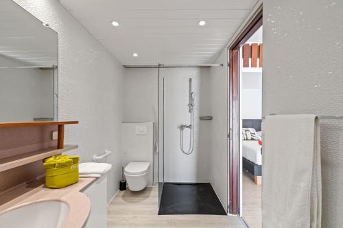 a bathroom with a shower and a toilet and a sink at Villa Lueurs du Rocher in Le Diamant