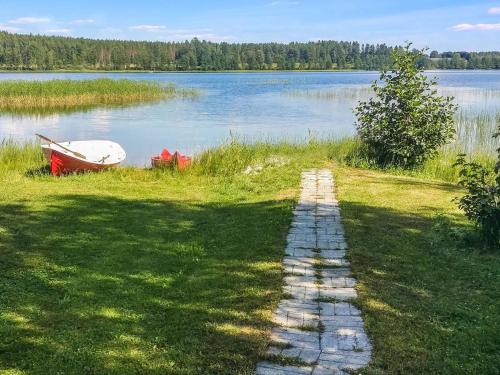 a pathway leading to a lake with a boat on it at Holiday Home Eden by Interhome in Kuusa