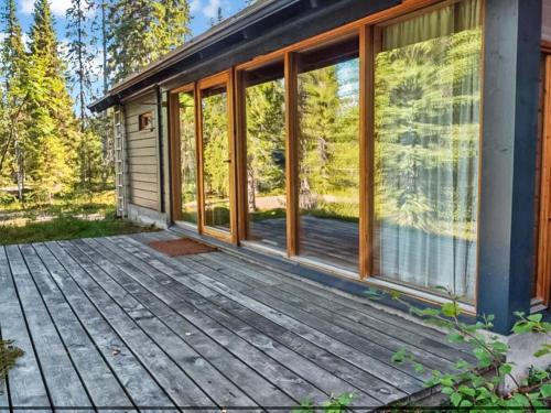 a house with a wooden deck and windows at Holiday Home Sinikuono by Interhome in Ylläsjärvi