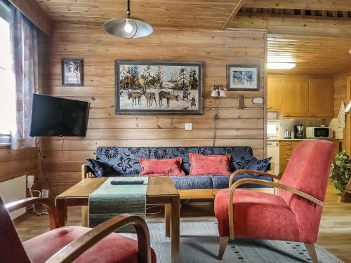 a living room with a couch and a table at Holiday Home Lomamaja 2 by Interhome in Raattama