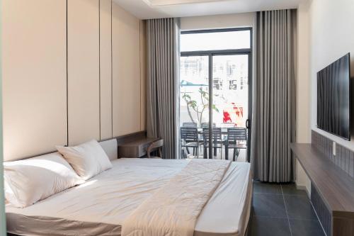 a bedroom with a large bed and a balcony at Biệt thự Hồ Tràm 3224 in Xuyên Mộc