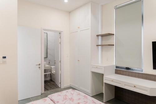 a white bathroom with a sink and a mirror at Biệt thự Hồ Tràm 3224 in Xuyên Mộc