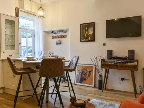 a living room with a table and a flat screen tv at Methera Cottage in Ambleside
