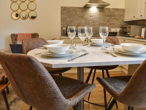 a table with wine glasses and plates on it at Methera Cottage in Ambleside
