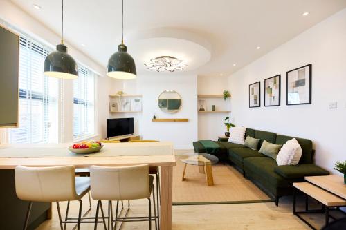 a living room with a green couch and a table at Aura - Elegant Retreat in Prime Leeds Location! in Headingley
