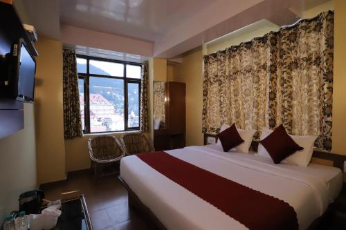 a bedroom with a large bed and a window at Harmony Sentiments in Shimla